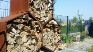 Holzunterstand Woodbee mit Holz gefüllt