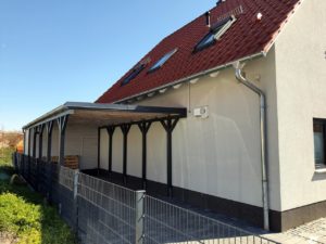 Blick auf ein Holzcarport am Haus montiert